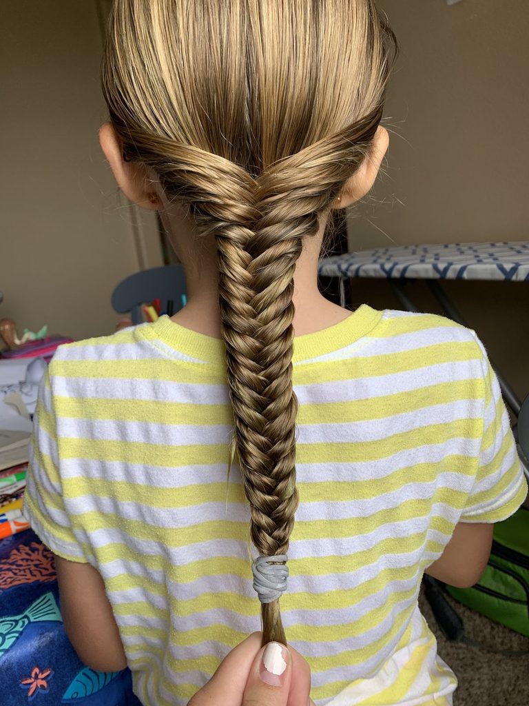 kid with fishtail braid as one of the halloween hairstyles for little girls
