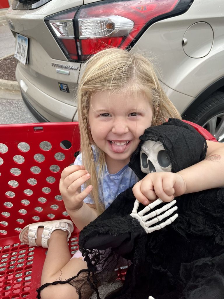 kid holding her halloween costume in excitement 
