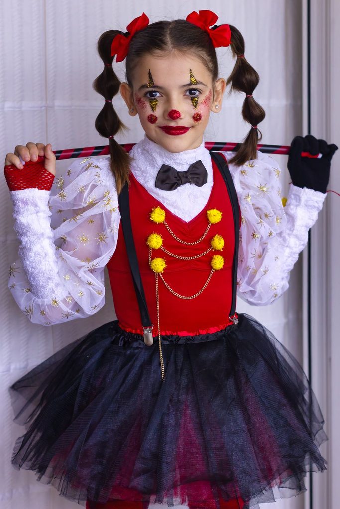 kid in clown costume and makeup