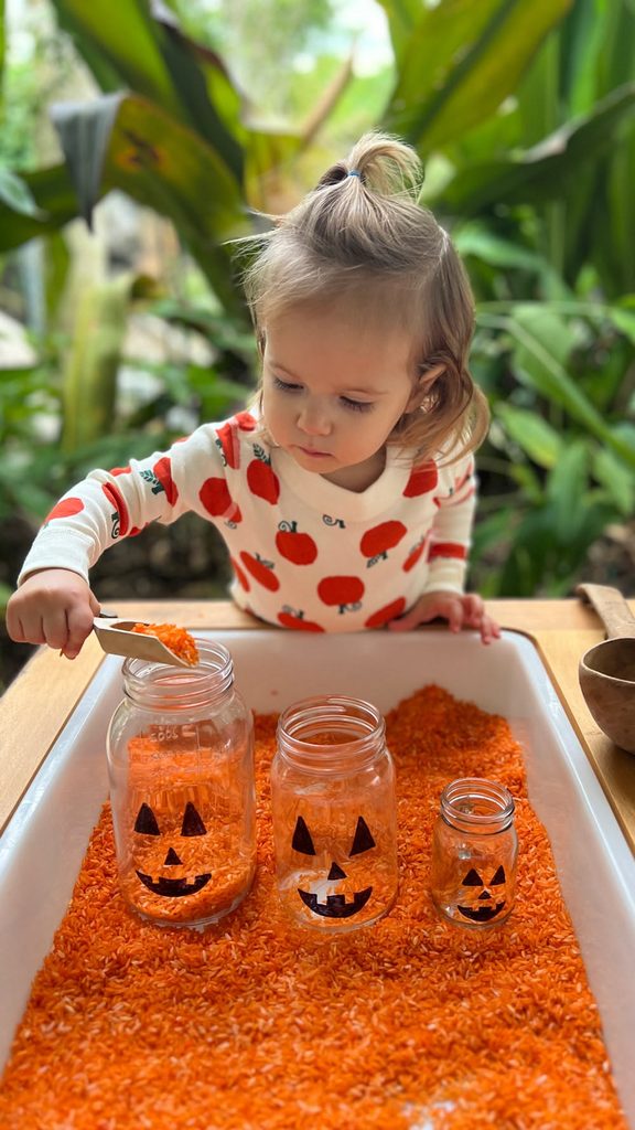kid in halloween sensory bin