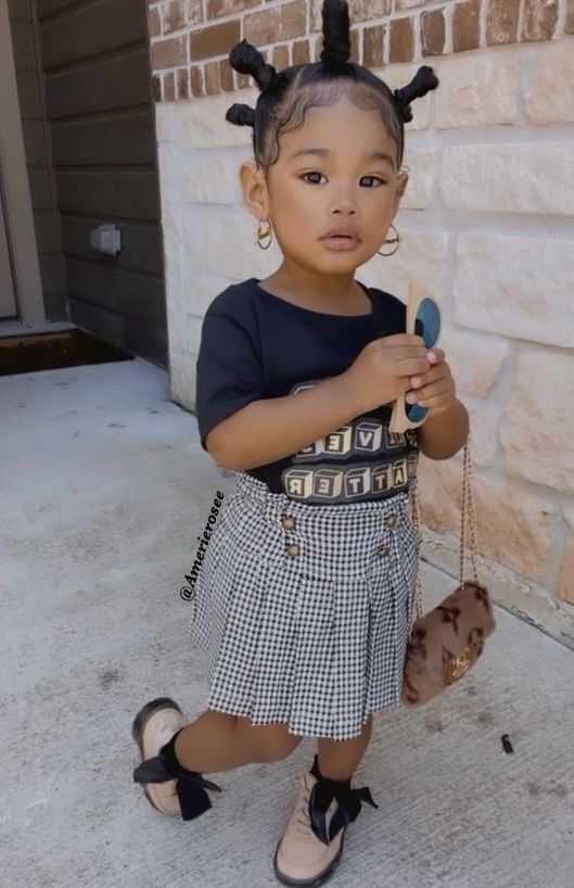 kid in short printed skirt and graphic Tee