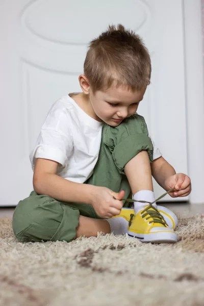 kid wearing his shoe