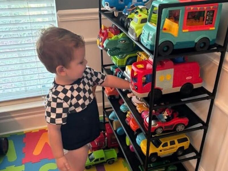 kid getting his toys from the rack
