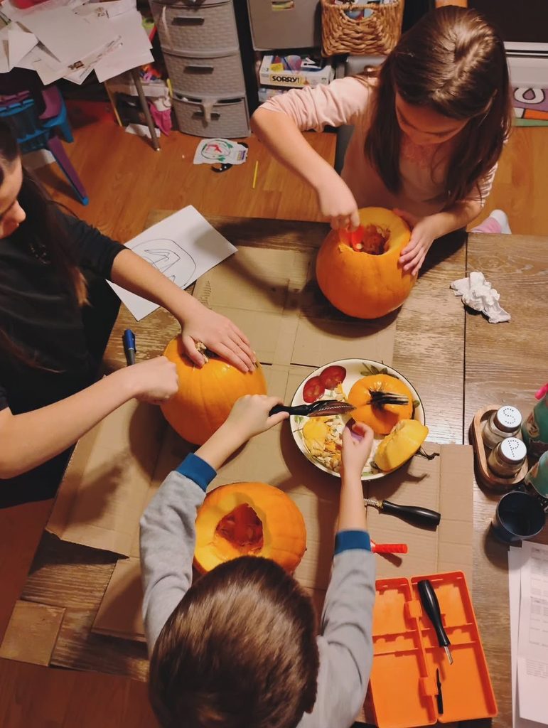 kids carving pumpkins as halloween learning activities for kids