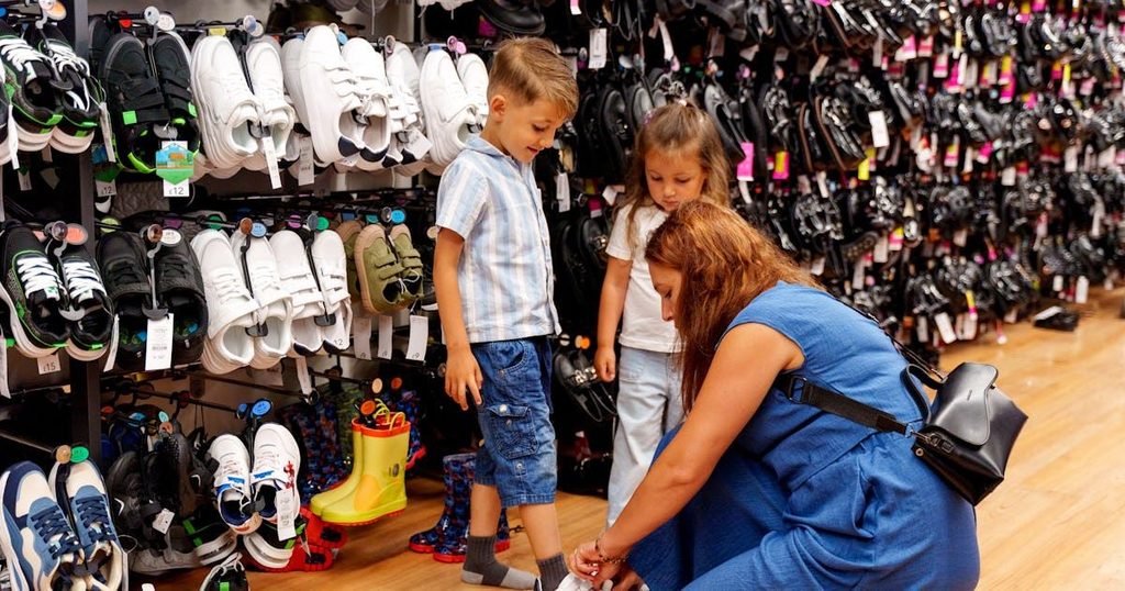 mom buying shoe for her kids