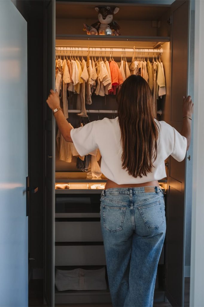 mom in kid's wardrobe looking for easy school morning clothes
