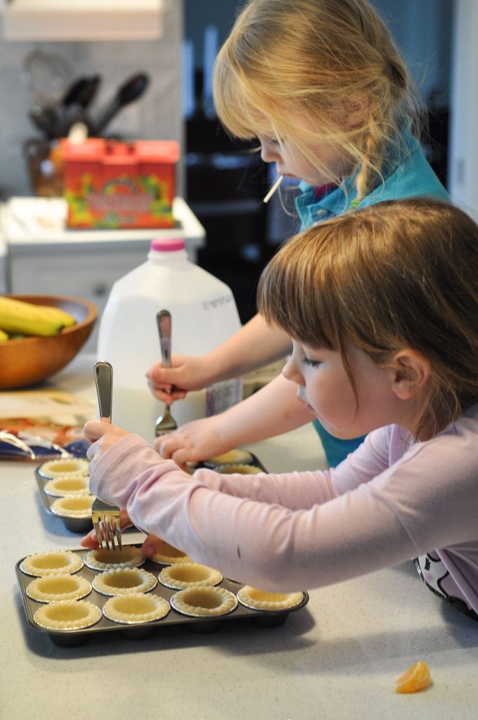 kids baking mini pies together as Thanksgiving activities for kids